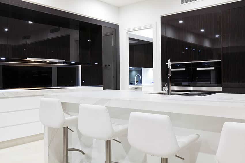 Modern black and white tone tone cabinet kitchen with white leather bar stools