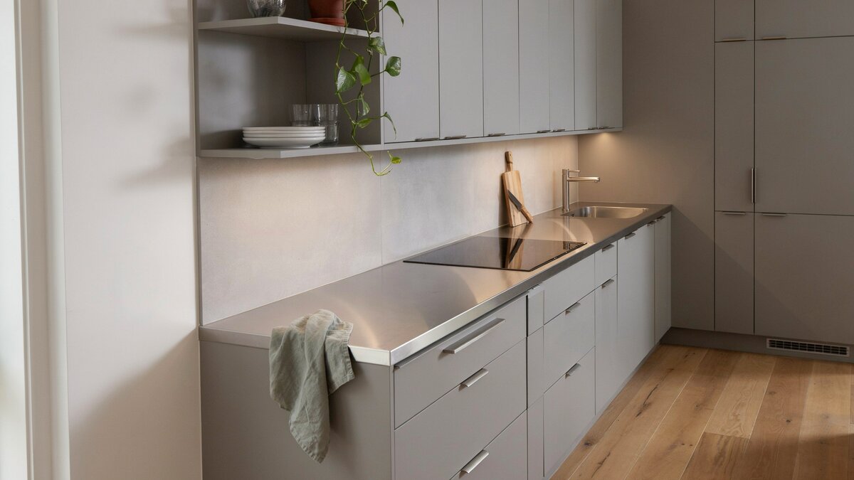 Light gray cabinets meet a stainless steel peninsula counter open at one end