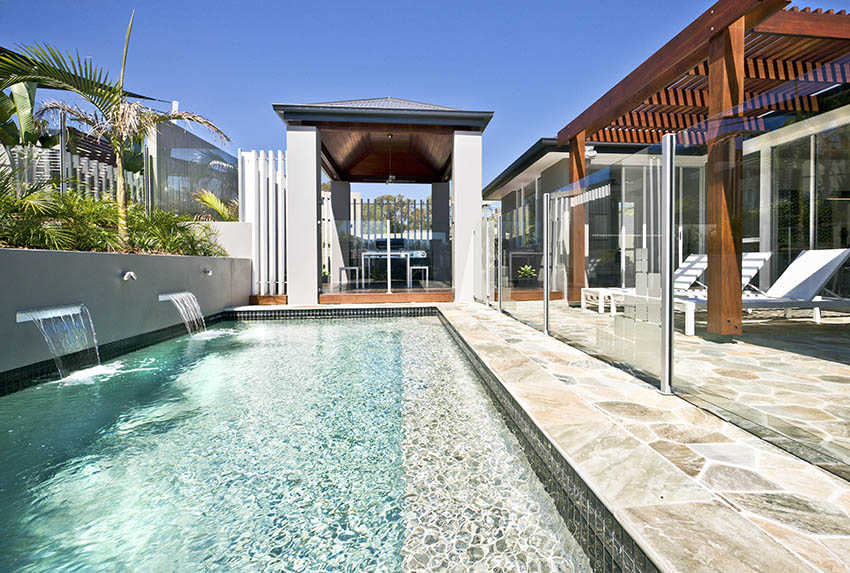 Modern pool with sheetfall waterfalls cabana and wood pergola