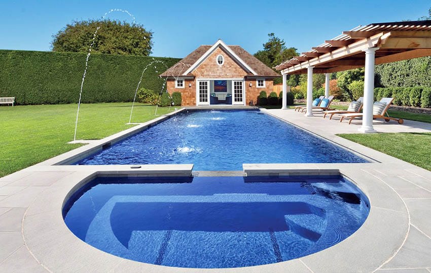 Rectangular swimming pool with semi circle hot tub, water fountains and pergola