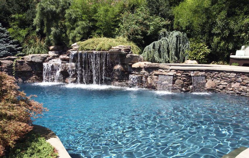 Swimming pool with natural stone waterfalls design