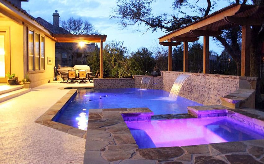 Pool with two waterfall styles, pergola, spa and purple lighting