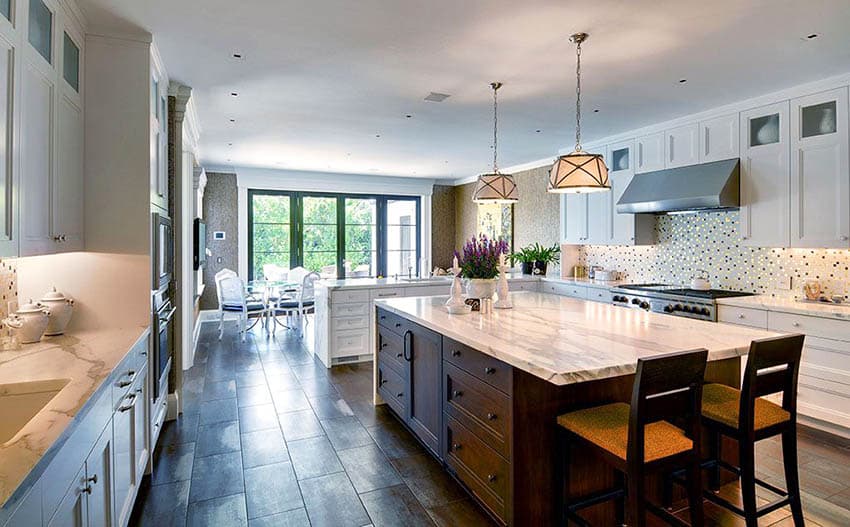 Kitchen with white cabinets and island with seating for two and long peninsula
