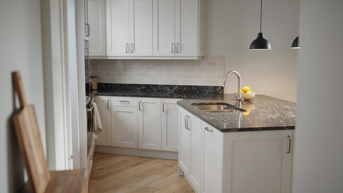 Contemporary white kitchen with mottled black galaxy granite countertops and gold flecks