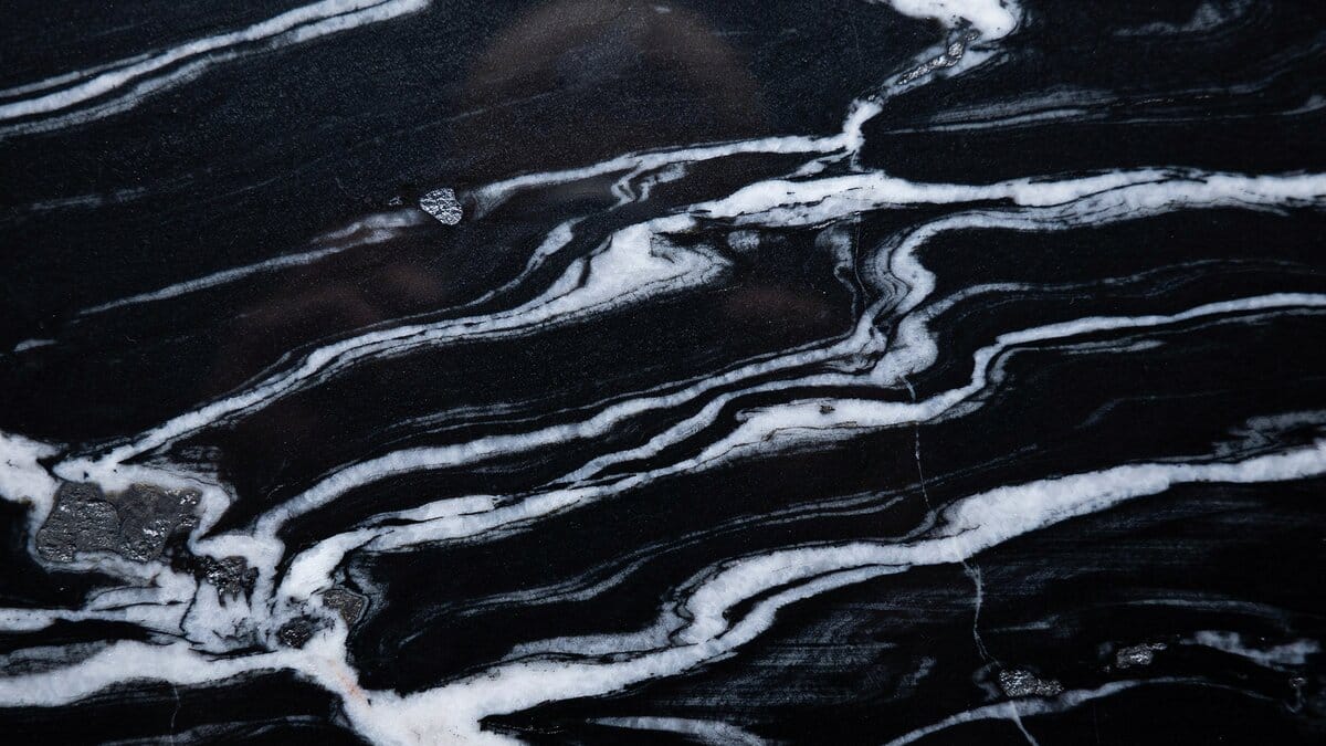 Polished Cosmic Black granite slab with swirling white veins and silver minerals