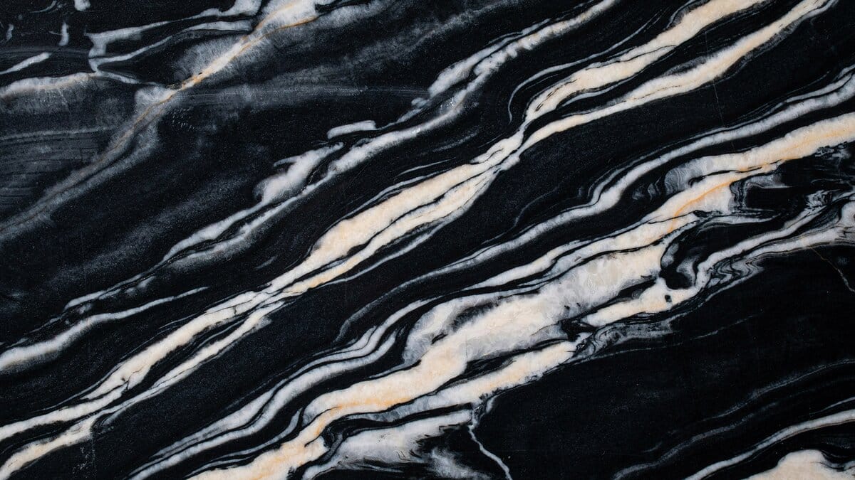 Polished Black Forest granite slab with sweeping white ivory and gray veins