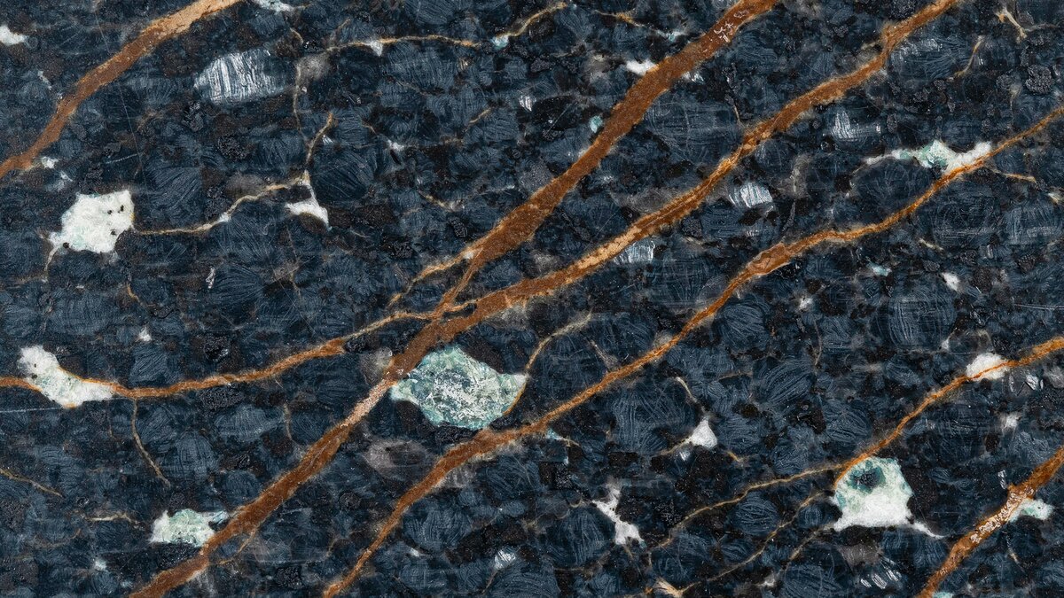 Polished Volcano Black granite slab with brown streaks and silver green minerals