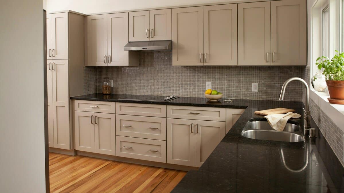 Kitchen with black satin granite countertop and gray mosaic tile backsplash