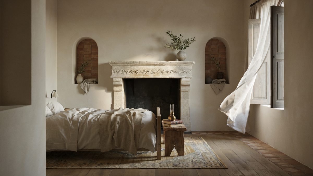 Carved limestone mantel set between two arched wall niches in a plaster bedroom