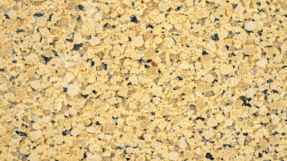 Evenly grained gold and amber crystals scattered with charcoal and gray specks