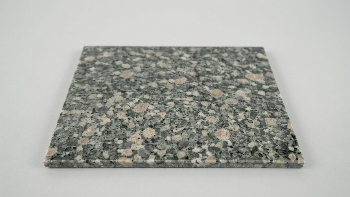 Single polished emerald granite tile with pebbled green gray and beige surface