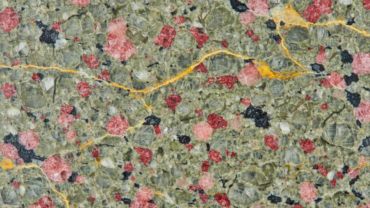 Olive green slab dotted with garnet pink clusters and golden veins
