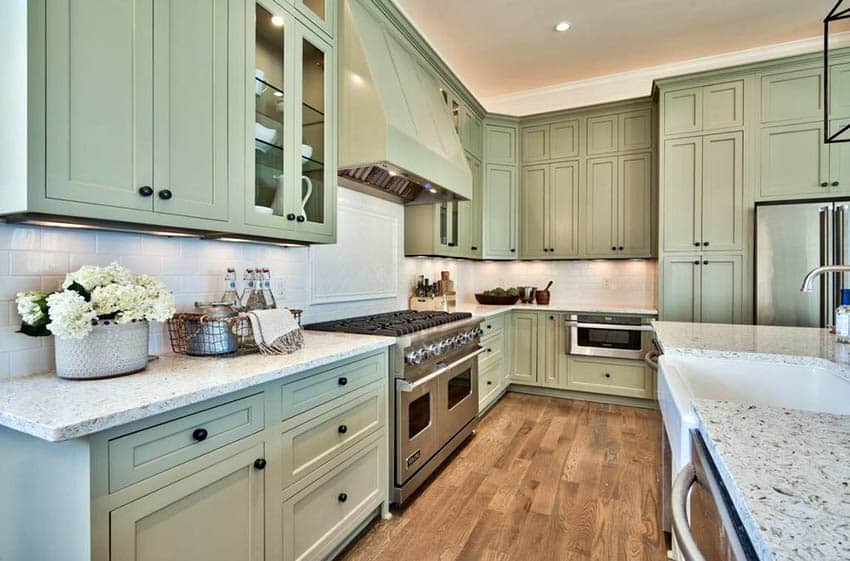 Kitchen with sage green flat panel cabinets and white granite countertops