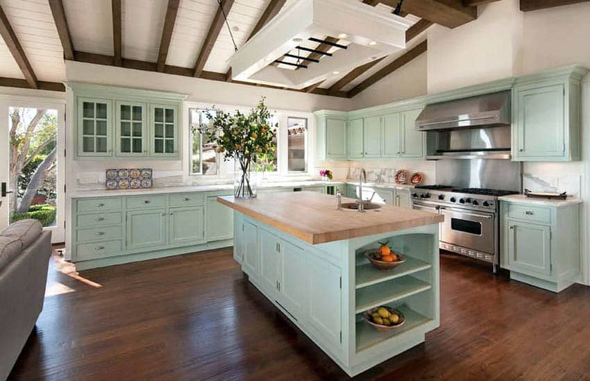 Kitchen with mint green cabinets and painted white wood ceilings with wood beams