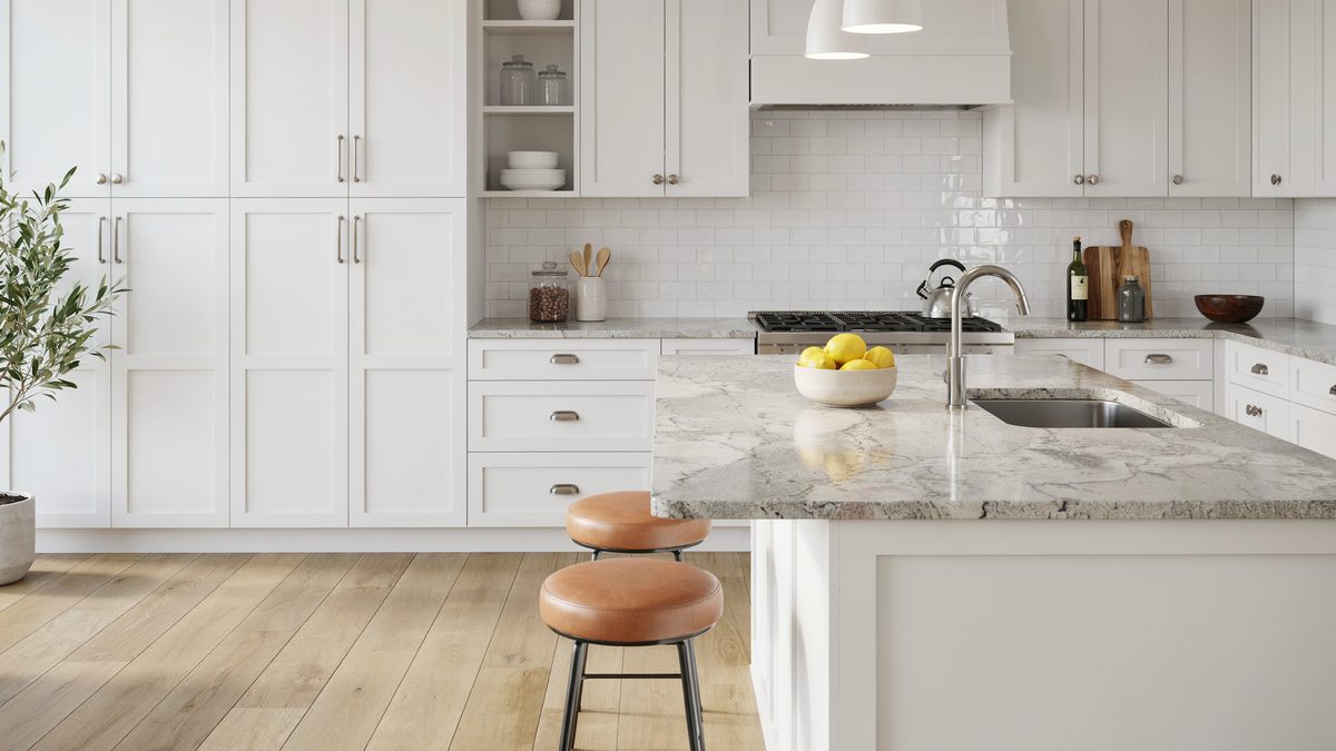 Floor to ceiling white cabinets framing cool gray beige counters and a leather stool