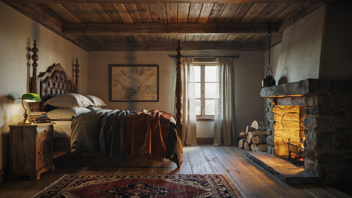 Open stone hearth burning next to a carved four poster under dark plank ceilings