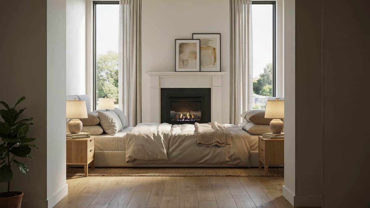 White painted mantel with a brass firebox framed by two tall bright windows