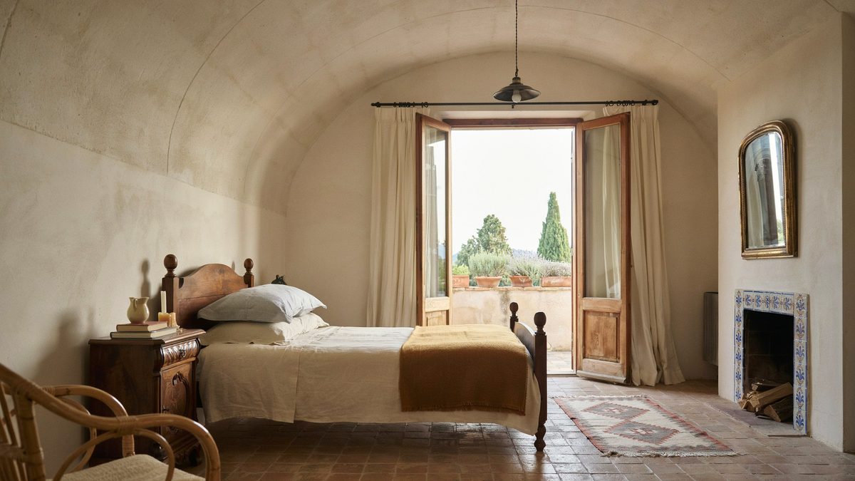 Vaulted plaster ceiling above a tiled corner hearth and open terrace doors