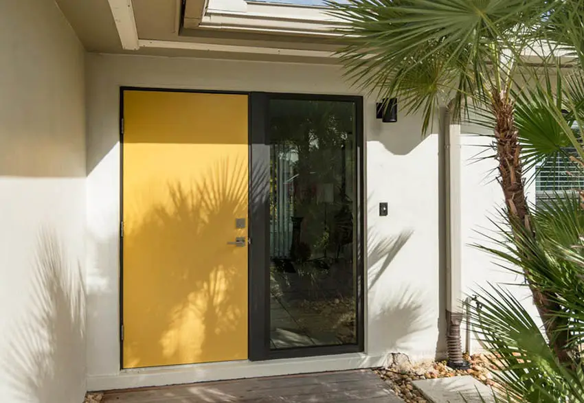 House with yellow sliding door and tropical landscaping