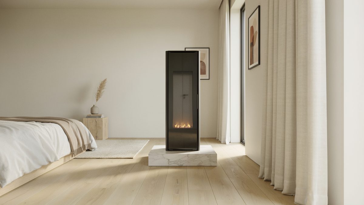 Slim black freestanding firebox on a low marble plinth in a pale calm room
