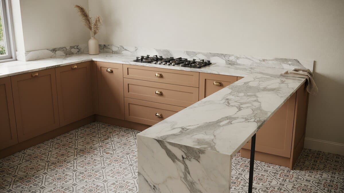 Calacatta marble peninsula wrapping a built in cooktop over mosaic tile flooring