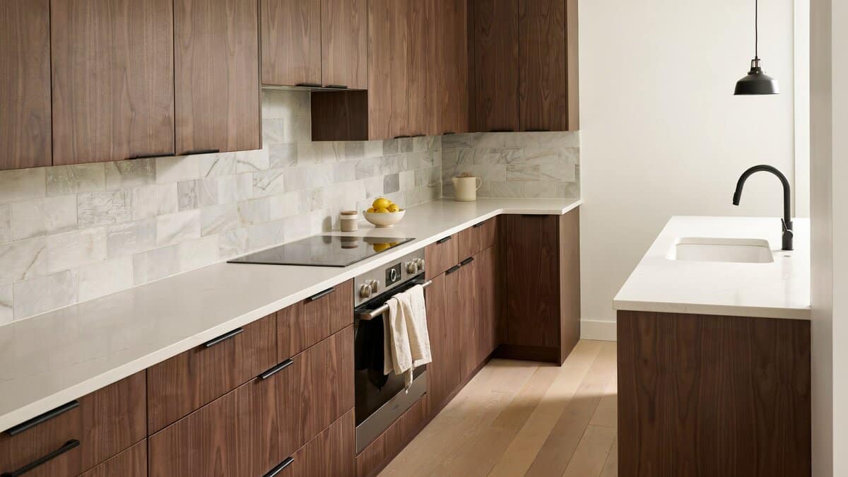 Honed marble tile meeting arctic white quartz on stained white oak cabinets