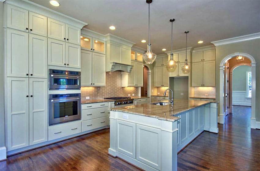 Traditional kitchen with green kitchen cabinets wood floors and beige granite