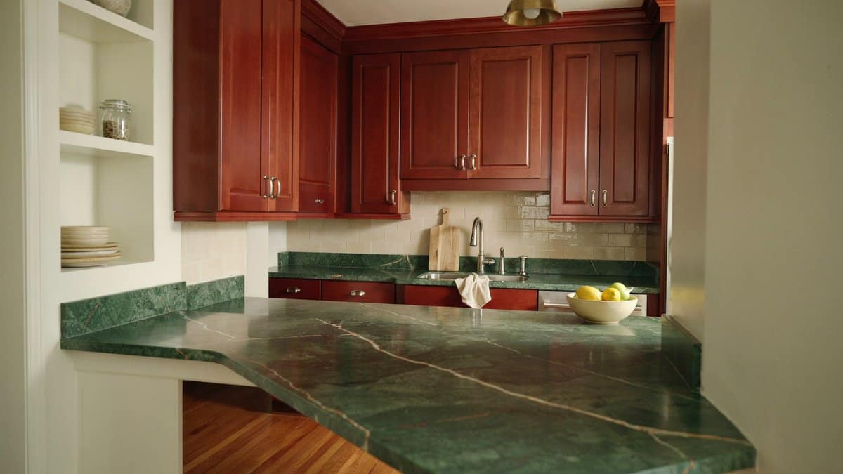 Cherry cabinet kitchen with wraparound green granite counter and raised bar ledge