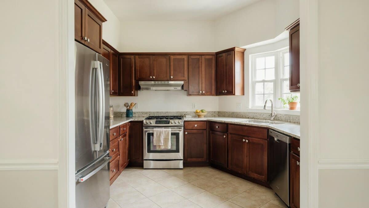 Mahogany shaker cabinets wrapping three walls under speckled granite and white paint