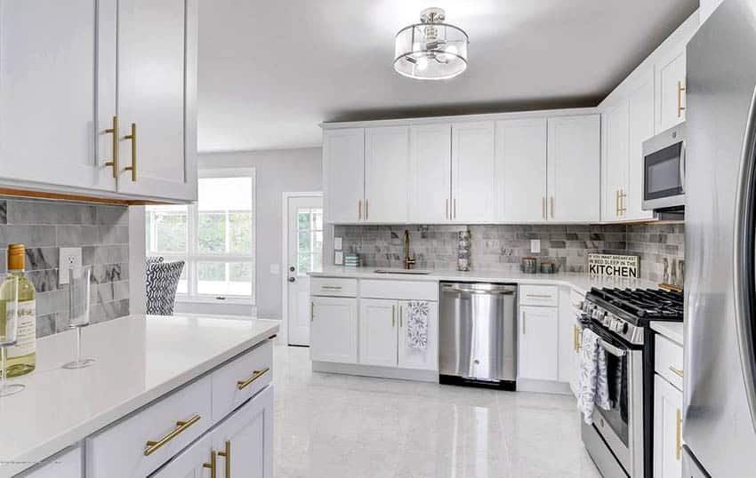 White cabinet kitchen with marble tile floors and marble backsplash