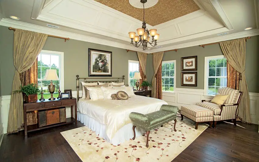 Bedroom with green paint and white wainscoting with wood flooring