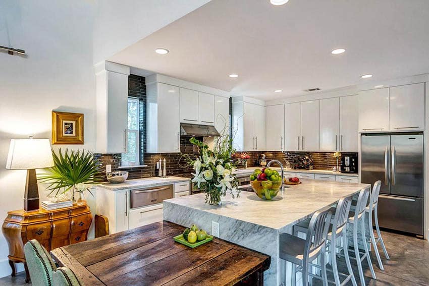 Kitchen with calacatta vagli marble island counter and wood dining table