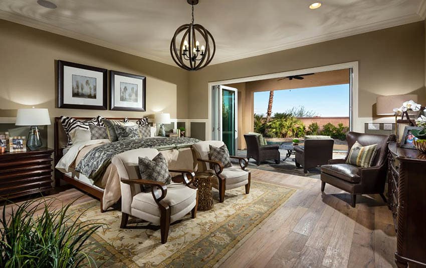 Bedroom with brass color walls, wood plank floors and globe chandelier