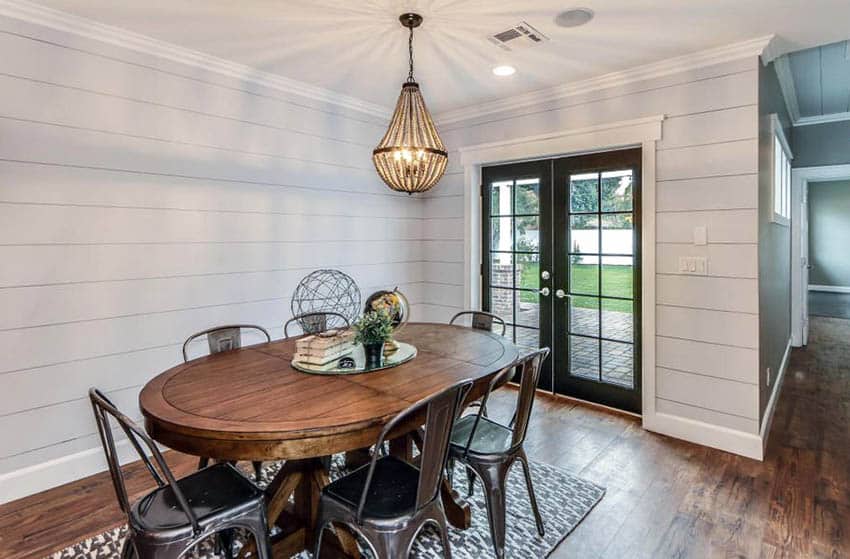 Room with shiplap walls, metal door and bead chandelier