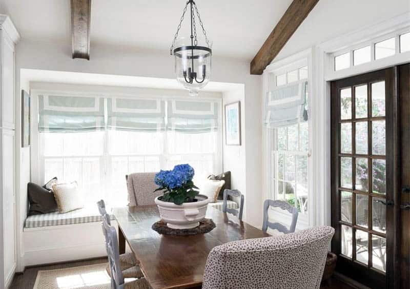 Cottage style dining room with wood french doors and open beam ceiling