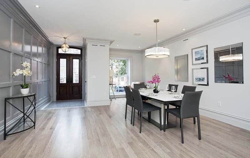 Room with grey panel walls, drum chandelier and console table in black finish