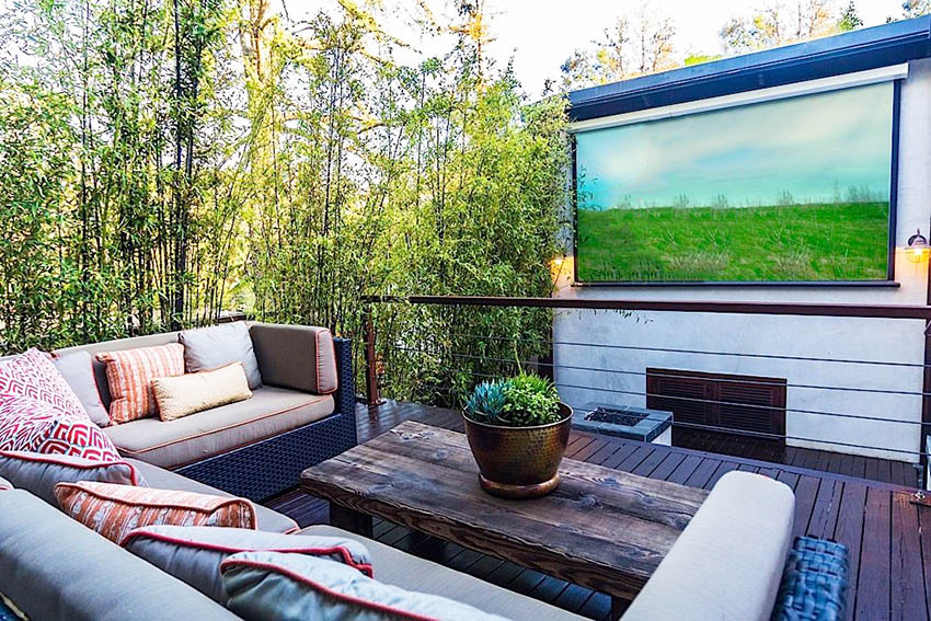 Elevated wood deck with outdoor furniture and projection screen