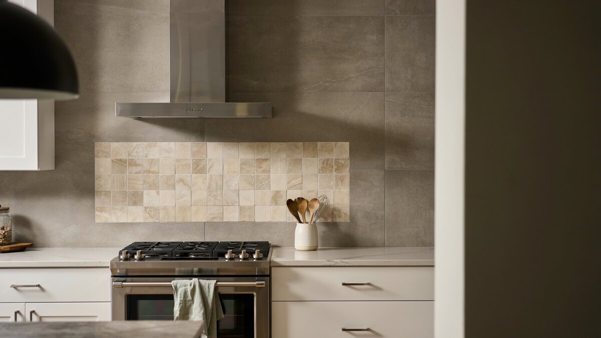 Tumbled travertine mosaic panel set inside darker honed travertine wall tile