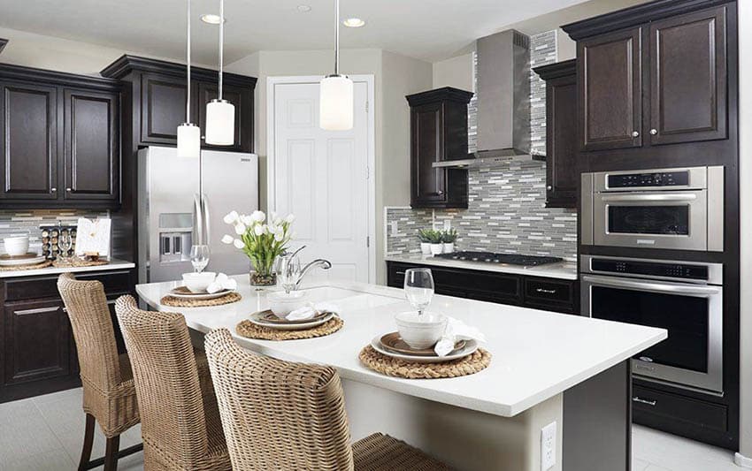 Kitchen with white quartz countertop dark cabinets and metallic glass mosaic tile backsplash