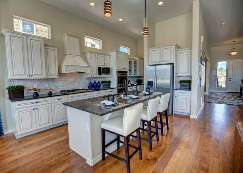 Kitchen with distressed cabinets and black granite surface countertops