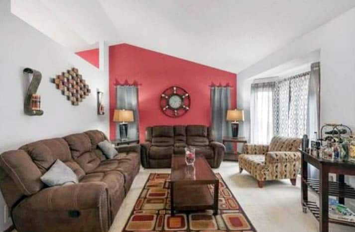 Living room with brown furniture red accent walls