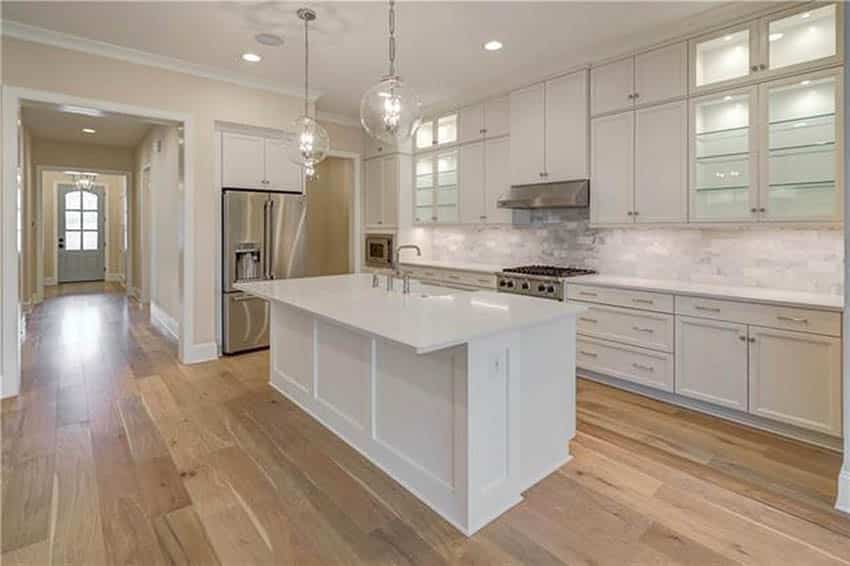 Long kitchen with overhang counter island with globe lights