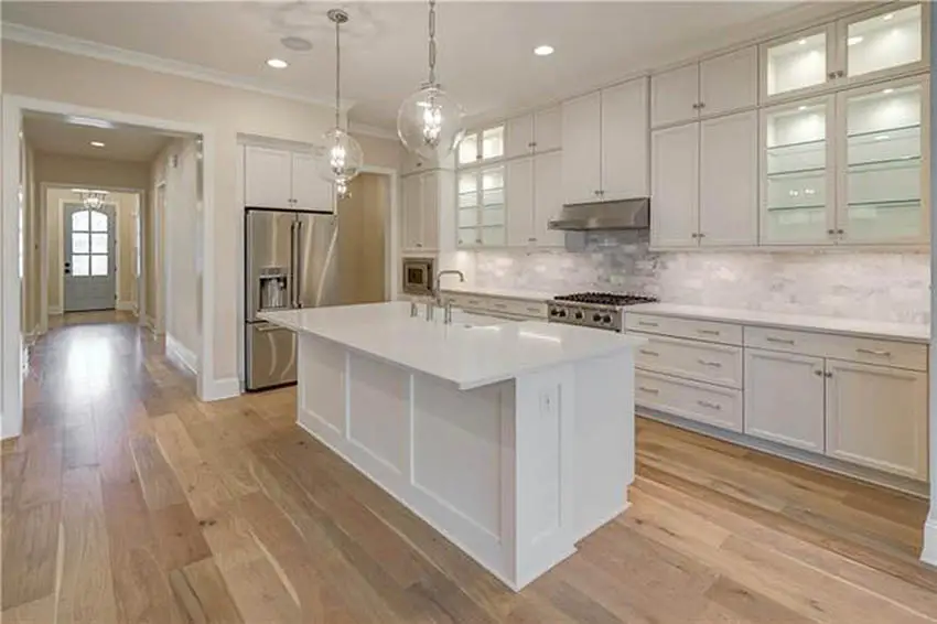 Long l shaped design kitchen with island with sink white cabinets