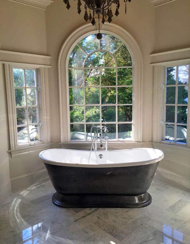 Master bathroom with herringbone carrara marble tile floors and freestanding tub Master bathroom with herringbone carrara marble tile floors and freestanding tub