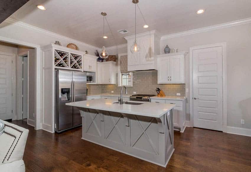 Kitchen with a light green island, white main cabinets and wine storage