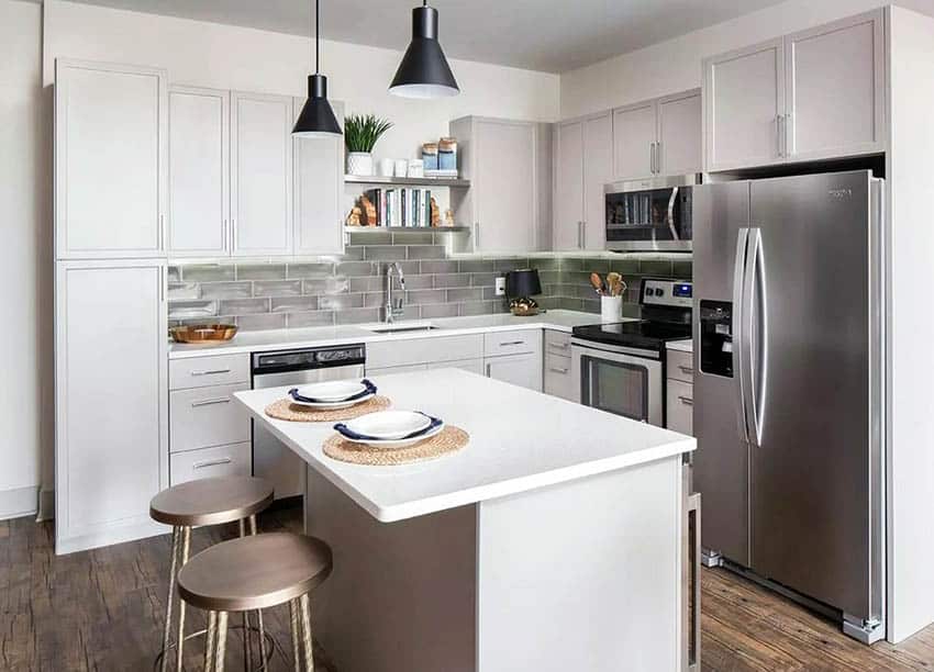 Small kitchen with dining island, glass backsplash and slab of quartz 