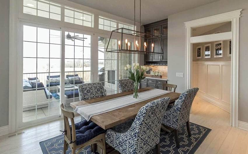 Room with upholstered chairs, floor to ceiling windows and candle chandeliers