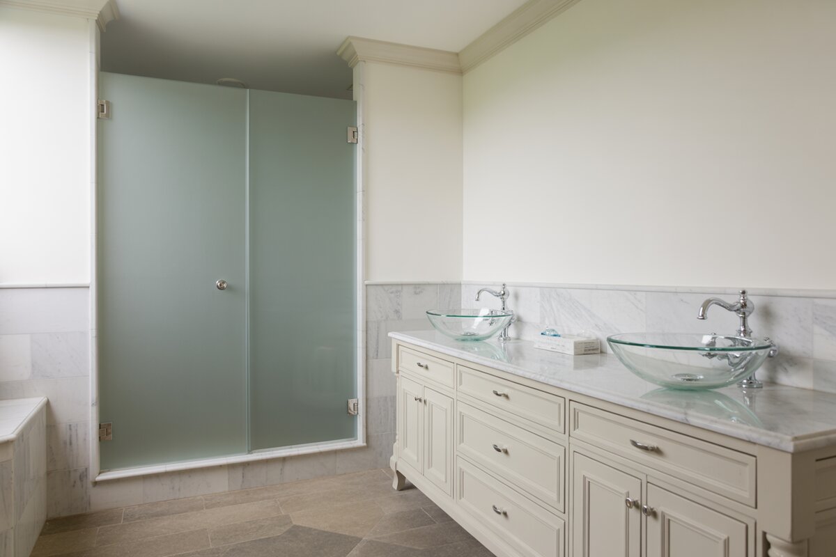 Transitional bathroom with white vanity, marble counter and frameless glass shower
