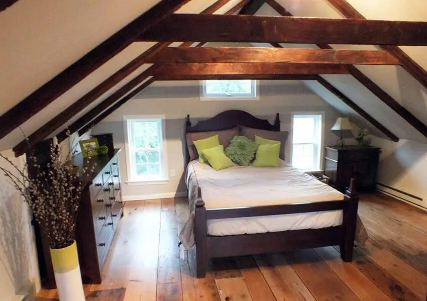 Attic bedroom with exposed wood beams and wood flooring
