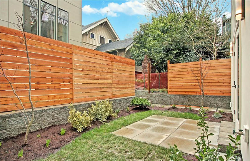 Backyard concrete patio with wood horizontal fence